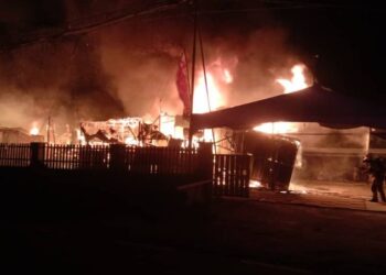 ANGGOTA bomba memadamkan kebakaran dua buah rumah yang mengorbankan kanak-kanak perempuan berumur enam tahun di Kampung Patau, Tambunan, pagi tadi. - UTUSAN/HARDY JOE