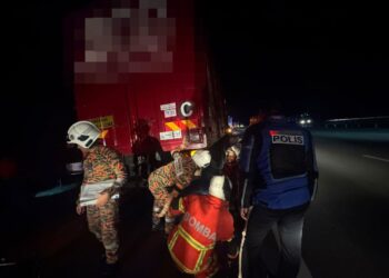 ANGGOTA bomba mengeluarkan mangsa yang tersepit dalam nahas membabitkan sebuah motosikal dan sebuah lori di Kilometer 254.6 Lebuhraya Utara-Selatan (PLUS) arah selatan, dekat Seremban tengah malam tadi.-GAMBAR/IHSAN POLIS