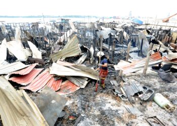 SEORANG anggota bomba melihat kesan kebakaran 30 buah rumah di perkampungan Orang Asli Teluk Jawa, Johor Bahru, Johor semalam. – UTUSAN/RAJA JAAFAR ALI