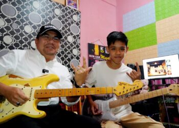 AMIZAR Abu Adam bersama Aiman Danish Iskandar Mohd. Khairul Izuan ketika program menyantuni generasi muda Felda di Felda Melati Jengka 11 di Maran, Pahang baru-baru ini.