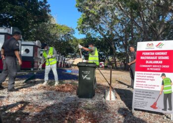 LIM Xiang Yong (dua kiri) dan Jufri Zulkifli (dua kanan) menjalani hukuman PKM sambil dipantau anggota SWCorp di perkarangan Stadium Darul Aman, Alor Setar, hari ini.