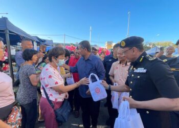 DZOWAHIR Ab Ghani (tengah) dan Stien Van Lutam (kanan) mengagihkan risalah pada program Kempen Keselamatan Jalan Raya sempena Tahun Baharu Cina Peringkat Negeri Kedah di Pasar Pagi Simpang Kuala, Alor Setar, hari ini.