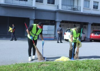 MOHD. Hashim Mohd. Nor dan Herrykurniawan ketika menjalani perintah khidmat masyarakat di Bandar Nilai, Seremban hari ini.- UTUSAN / NOR SHAFIQAH MOHD GHAZALI
