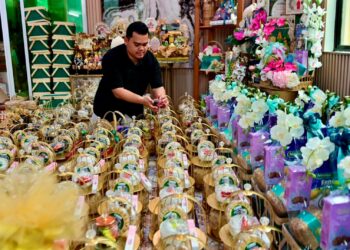 MUHAMMAD Shohamil Haffiz Salleh menyusun hamper perayaan yang ditempah pelanggan ketika ditemui Mingguan Malaysia di rumahnya di Kampung Undang, Marang, Terengganu. – MINGGUAN/PUQTRA HAIRRY