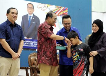 MOHAMED Khaled Nordin menyampaikan sumbangan kepada seorang kanak-kanak pada program Kembali Ke Sekolah Parlimen Pasir Gudang di Bandar Seri Alam, Johor Bahru, Johor.