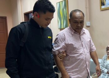 ABDUL Rahim Salleh (kanan) dibawa keluar oleh Pegawai SPRM selepas selesai perbicaraan di Mahkamah Sesyen Tawau, Sabah hari ini.UTUSAN/ NASRAWATI SYARIFUDDIN