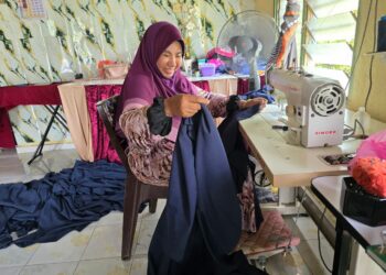 SANASIAH Uda Hasan menjahit langsir pelanggannya di Batu 10, Kampung Kubang Changdong, Parit, Perak. – UTUSAN/AIN SAFRE BIDIN