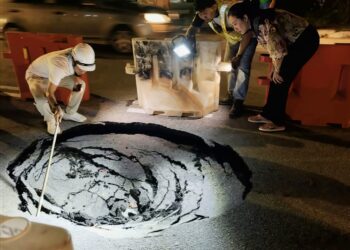 PHEE Syn Tze (kanan) ketika turun padang meninjau keadaan mendapan tanah yang membentuk lubang benam di Jalan Bagan Lalang, Butterworth, Pulau Pinang malam tadi.