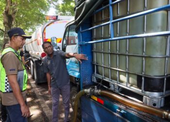 S. JEGAN (kanan) menunjukkan tangki IBC yang digunakan untuk menyimpan diesel bersubsidi dalam sebuah lori seberat 14 tan sebelum ia dipindahkan ke dalam sebuah lori tangki berhampiran di Simpang Ampat, Pulau Pinang hari ini.-UTUSAN/DANIAL SAAD