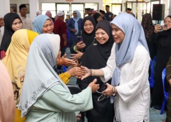 RINA JAINAL menyantuni rakyat dalam satu lawatan bertemu penduuddk kawasan Kukusan baru-baru ini.