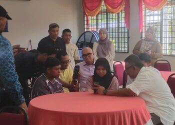 MEGAT Zulkarnain Omardin (kanan) menyantuni dua beradik dan menyampaikan hasrat Ahmad Zahid Hamidi menjadikan mereka sebagai anak angkat.