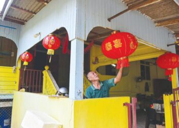 LIM Chong Swee memasang tanglung di hadapan rumahnya sebagai persediaan menyambut Tahun Baharu Cina di Kampung Tembok Baru, Wakaf Tapai, Marang, Terengganu. – UTUSAN/PUQTRA HAIRRY