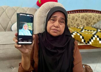 NORSIAH Yahya menunjukkan gambar Allahyarham Zahrullail Basir ketika ditemui di Taman Sultan Abdul Halim, Tanjung Bendahara di Alor Setar, Kedah semalam.