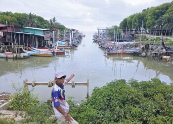 Md. Dahari Md. Tarsim menunjukkan keadaan muara sungai yang cetek akibat cuaca panas di jeti Parit Haji Dollah, Sungai Tiram, Lekir, Lumut. 
– UTUSAN/AIN SAFRE BIDIN