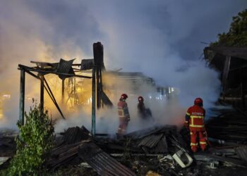 PASUKAN bomba berusaha memadam kebakaran membabitkan dua rumah papan di Perkampungan Bukit Ubi, Kuantan, Pahang. - IHSAN BOMBA