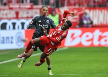 Pemain pertahanan Bayern Munich dari Kanada, Alphonso Davies (kanan) diasak dan dijatuhkan oleh penyerang Eintracht Frankfurt dari Perancis, Jean-Matteo Bahoya dalam aksi Bundesliga Jerman antara Bayern Munich dan Eintracht Frankfurt di Munich, selatan Jerman, kelmarin. - AFP