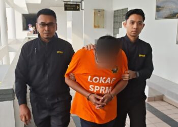 TERTUDUH dibawa keluar dari Mahkamah Majistret, Ayer Keroh, Melaka selepas permohonan reman kerana disyaki meminta dan menerima rasuah kira-kira RM10,000. - UTUSAN/AMRAN ALI