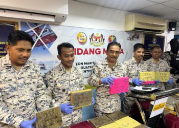 ROMLI Mustafa (tiga dari kiri) menunjukkan ketulan mampat dipercayai ganja yang dirampas di pesisir pantai Kuala Perlis semalam.-UTUSAN/ASYRAF MUHAMMAD