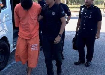 TERTUDUH semasa dibawa polis untuk prosiding perbicaraan di Mahkamah Kota Bharu, Kelantan. - UTUSAN/ROSLAWANI CHE SOH