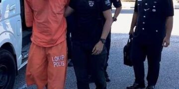 TERTUDUH semasa dibawa polis untuk prosiding perbicaraan di Mahkamah Kota Bharu, Kelantan. - UTUSAN/ROSLAWANI CHE SOH