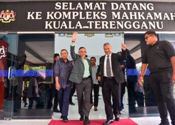 HANAFIAH Mat (tengah) semasa di pekarangan Mahkamah Sesyen Kuala Terengganu. - UTUSAN/PUQTRA HAIRRY