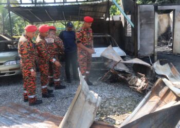 NOR Hisham Mohammad (depan) melihat kesan kebakaran rumah yang meragut lima nyawa  di Kampung Pamah Kulat, Raub, Pahang.
