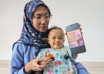 ANISAH Ab. Rahim bersama anaknya, Aisy Nur Dareesa Mohd. Sahril Azuan yang menghidap penyakit genetik jarang berlaku ketika lawatan Sukarelawan Bencana Melaka di Bertam, Melaka, semalam. - UTUSAN/AMRAN ALI.