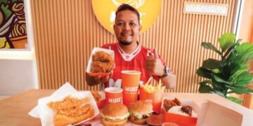 MUHAMMAD ZAKI Shafie bersama menu jenama Muiz Hot Chicken di restoran miliknya di Bandar Sri Putra.
– MINGGUAN/MUHAMAD IQBAL ROSLI