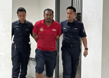 TERTUDUH semasa dibawa oleh polis untuk prosiding perbicaraan di Mahkamah Sesyen, Kota Bharu, Kelantan.