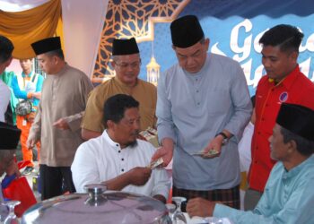 PENGERUSI Jawatankuasa Pelancongan, Seni dan Budaya Melaka, Datuk Abdul Razak Abdul Rahman menyampaikan sumbangan kepada veteran tentera sambil diiringi Nasrul Ahmad (kiri) di Masjid As-Saadah, Ujong Pasir, Melaka semalam. - UTUSAN/AMRAN MULUP