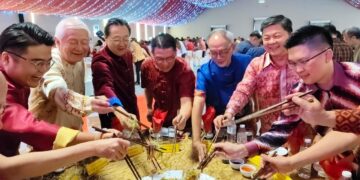 NGA Kor Ming (tengah) menggaul Yee Sang pada Majlis Sambutan Tahun Baharu Cina oleh Dewan Perhimpunan Cina Perak di Ipoh hari ini.