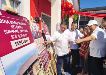 NGA Kor Ming (kiri) melihat gambar rumah lama Chan Fook Yan (dua dari kanan) sebelum dibina baharu dalam program Sentuhan Kejayaan Kampung Baru 2025 di Kampung Baru Simpang Jalong, Sungai Siput hari ini.