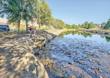 PEKEBUN menunjukkan keadaan air sungai yang hitam dan berbau busuk di kawasan Bukit Rambai, Melaka, semalam. – UTUSAN/AMRAN ALI