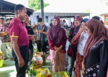 MOHD. Musfi Lat (kiri) beramah mesra bersama pengunjung pada Program Jualan Rahmah Madani (PJRM) di Masjid Kampung Banggol Binjai, Tepoh, Kuala Nerus, Terengganu. - UTUSAN/PUQTRA HAIRRY