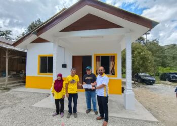 ZAFRI Ab. Halim (kanan) menyerahkan papan tanda sebagai simbolik serah terima rumah baharu kepada Razak Ibrahim di Kampung Chucuh Puteri B, Kuala Krai, Kelantan. - UTUSAN/YATIMIN ABDULLAH