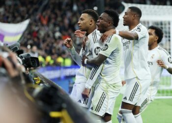 Penyerang Perancis Real Madrid, Kylian Mbappe (kiri) meraikan jaringannya bersama rakan sepasukan, Vinicius Junior (tengah) selepas menjaringkan gol kedua pasukan pada perlawanan Liga Sepanyol menentang Rayo Vallecano di Stadium Santiago Bernabeu, Madrid, semalam. - AFP