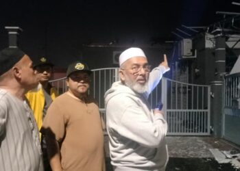 SYED Abu Hussin Hafiz Syed Abdul Fasal menunjukkan keadaan rumah penduduk yang rosak akibat ribut di Taman Damai, Taiping semalam. - UTUSAN/WAT KAMAL ABAS
