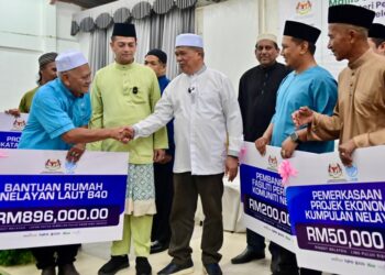 MOHAMAD Sabu (tengah) beramah mesra bersama wakil penerima pada Majlis Sentuhan AgroMADANI dan Iftar Bersama Nelayan Kuala Terengganu Utara di Kuala Nerus, Terengganu. - UTUSAN/PUQTRA HAIRRY