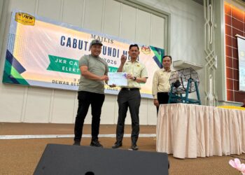 NIK Badlihisham Nik Ismail (tengah) menunjukkan nombor cabutan undi sambil menyerahkan surat setuju terima kepada kontraktor sempena Cabutan Kerja Undi JKR Cawangan Kejuruteraan Elektrik Kelantan di Tunjung, Kota Bharu, Kelantan. - UTUSAN/ ROSLIZA MOHAMED