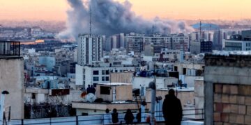 SEORANG individu berdiri di atas bumbung sebuah bangunan melihat kepulan asap selepas serangan ke atas ibu negara Iran, Teheran, Selasa lalu.