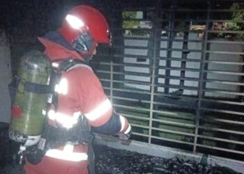 SEORANG anggota bomba menunjukkan keadaan rumah inap desa yang hampir musnah dalam kebakaran di Solok Sungai Emas, Batu Ferringhi, Pulau Pinang awal pagi tadi.-IHSAN JBPM PULAU PINANG