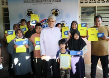 SAIFUDDIN Nasution Ismail (tengah) bersama sembilan sekeluarga membabitkan dua generasi yang menerima sijil kelahiran dan Mykad menerusi program Mekar di Kampung Simpul Berlubang, Machang, Kelantan, kelmarin.