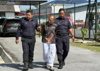 ZAINIZAN Zainal diiringi anggota polis dibawa keluar dari Mahkamah Majistret Rembau selepas prosiding sebutan semula kes pembunuhan Suri Narudin hari ini. -UTUSAN / NOR SHAFIQAH MOHD GHAZALI