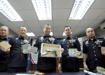 AB. Rahaman Arsad menunjukkan sepucuk pistol tiruan yang dirampas dalam kes samun pada sidang akhbar di IPK Johor, Johor Bahru hari ini. - UTUSAN/RAJA JAAFAR ALI