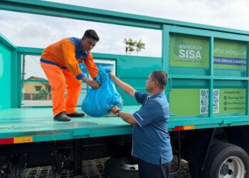 MOHD. NORLISAM Mohd. Nordn (kiri) melakukan gimik mengangkat sampah pada Program Operasi Sisa Pepejal Aidilfitri Johor 2026 yang diadakan di Kampung Dato’ Onn Larkin, Johor Bahru.