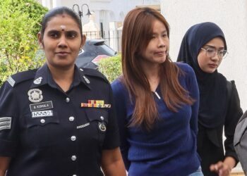 LEE Lay Peng (tengah) diiringi oleh anggota polis ketika dihadapkan ke Mahkamah Sesyen George Town, Pulau Pinang atas empat pertuduhan iaitu melakukan pecah amanah wang sebuah syarikat berjumlah RM677,629. - UTUSAN/DANIAL SAAD