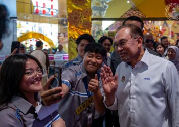 Pengunjung mengambil peluang berswafoto bersama Anwar Ibrahim pada Majlis Perasmian Hari Pengguna Kebangsaan 2026 di Kota Kinabalu, Sabah, semalam. – PEJABAT PERDANA MENTERI