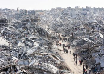 PENDUDUK melalui kawasan penempatan yang musnah sepenuhnya selepas dibedil oleh tentera Zionis. 
– AFP