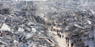 PENDUDUK melalui kawasan penempatan yang musnah sepenuhnya selepas dibedil oleh tentera Zionis. 
– AFP