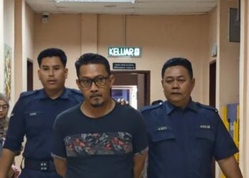 Tertuduh, Hadriansyah Sabran, dibawa keluar dari Mahkamah Majistret Tawau selepas dituduh mengedar dadah lebih tiga kilogram. - UTUSAN/NASRAWATI SYARIFUDDIN